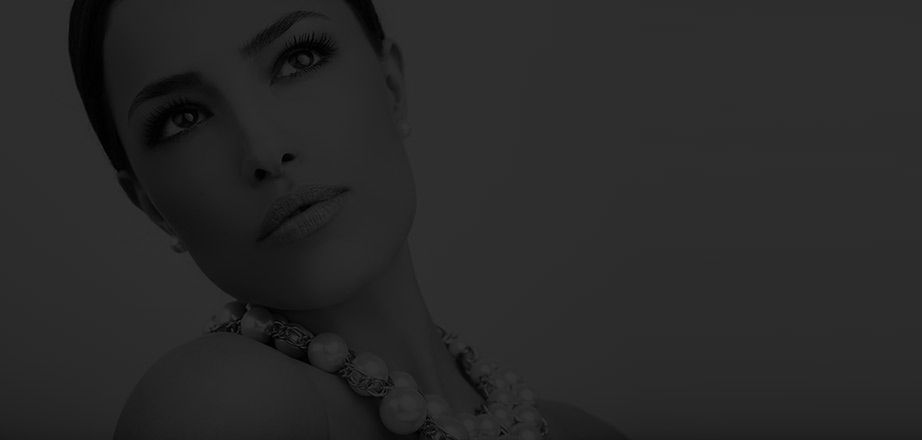 Elegant woman with jewelry on a dark background.