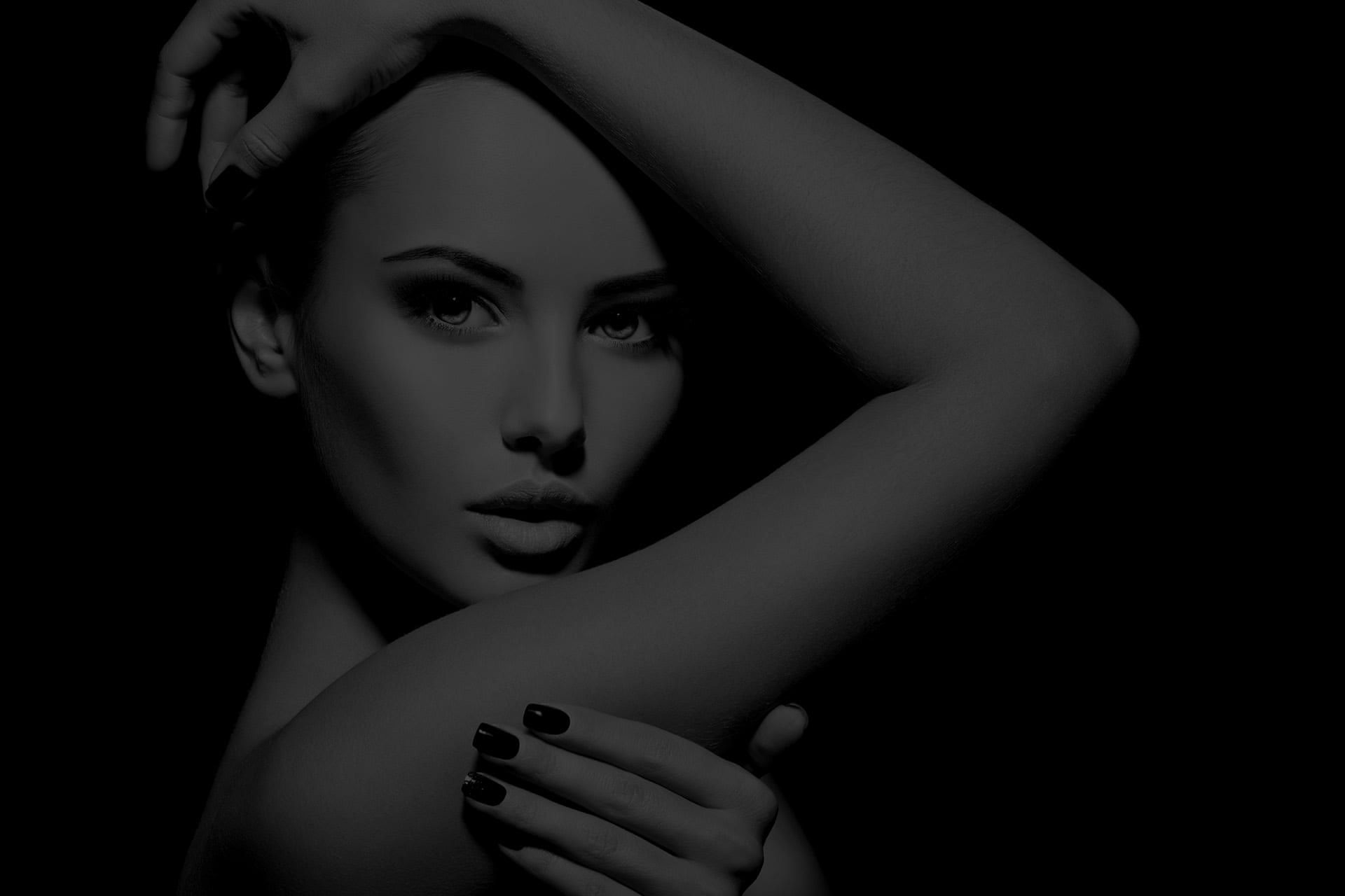 Woman posing dramatically against a dark background.