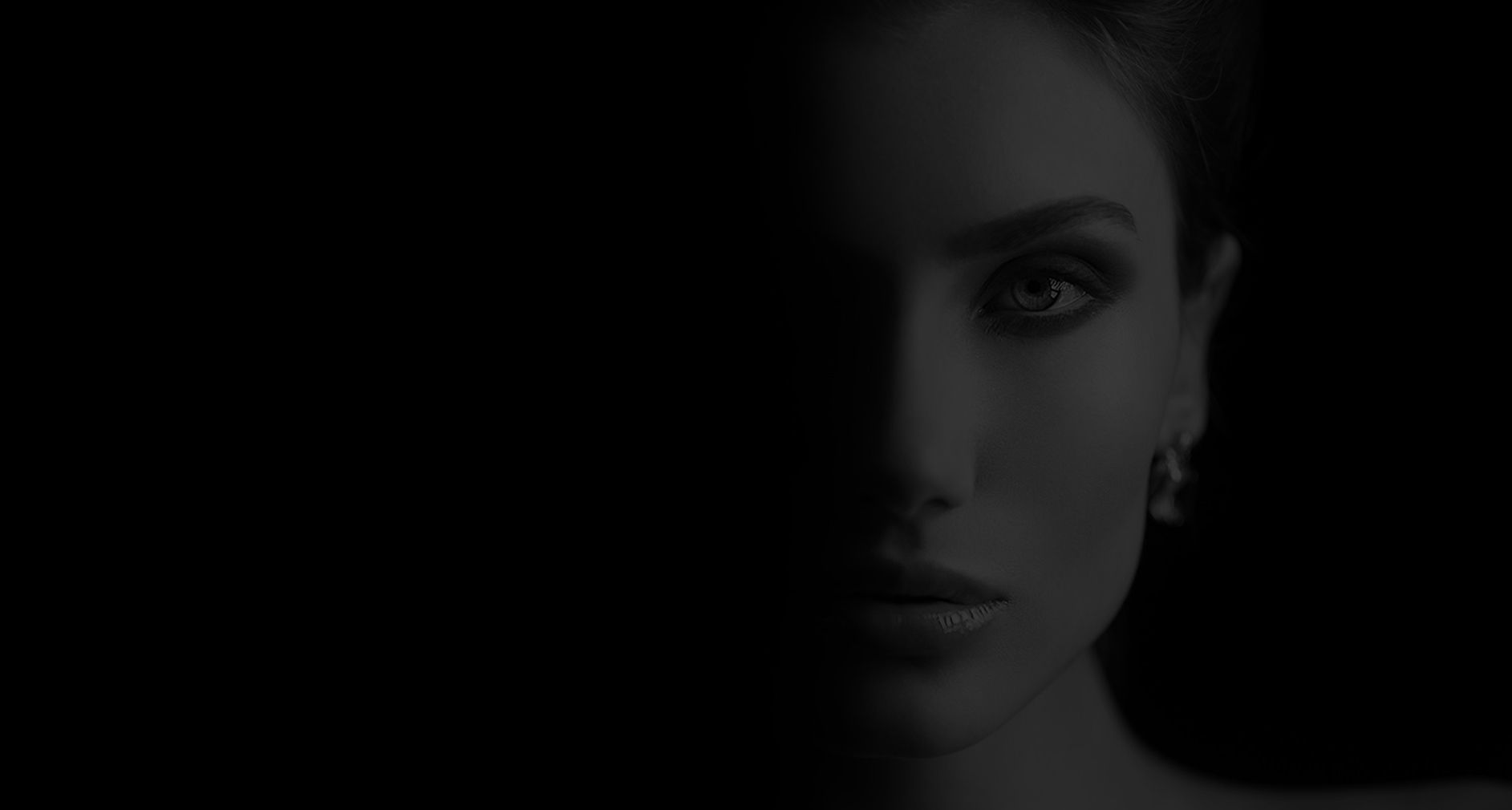 Half of a woman's face in shadow.
