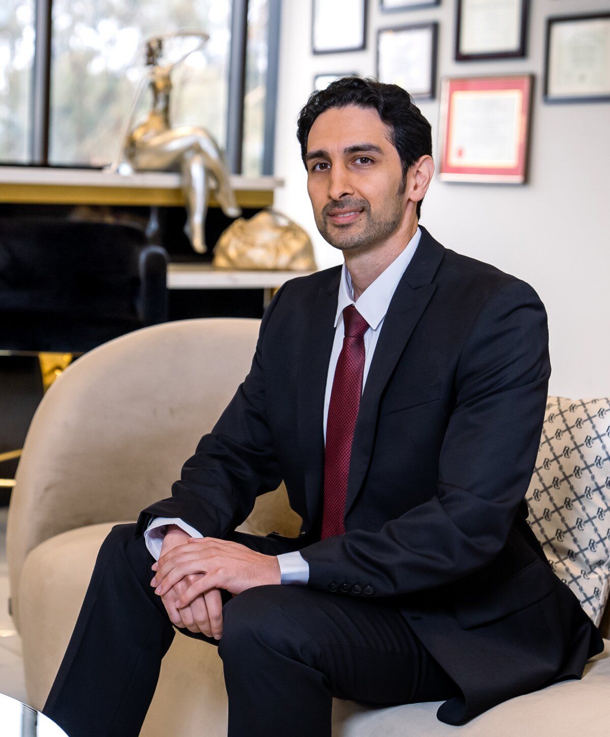 Professional man seated in office attire.