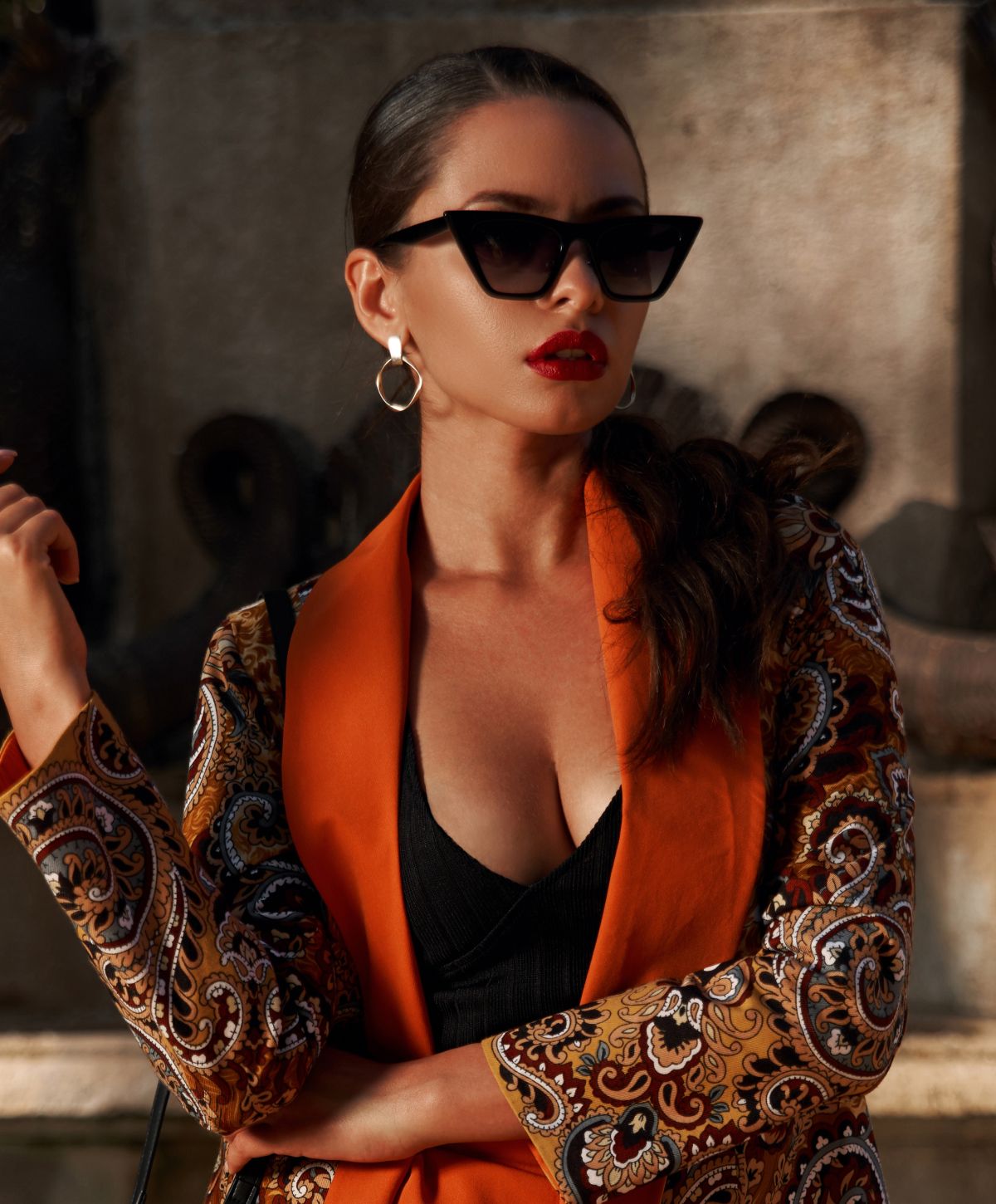 Fashionable woman in sunglasses and colorful jacket.