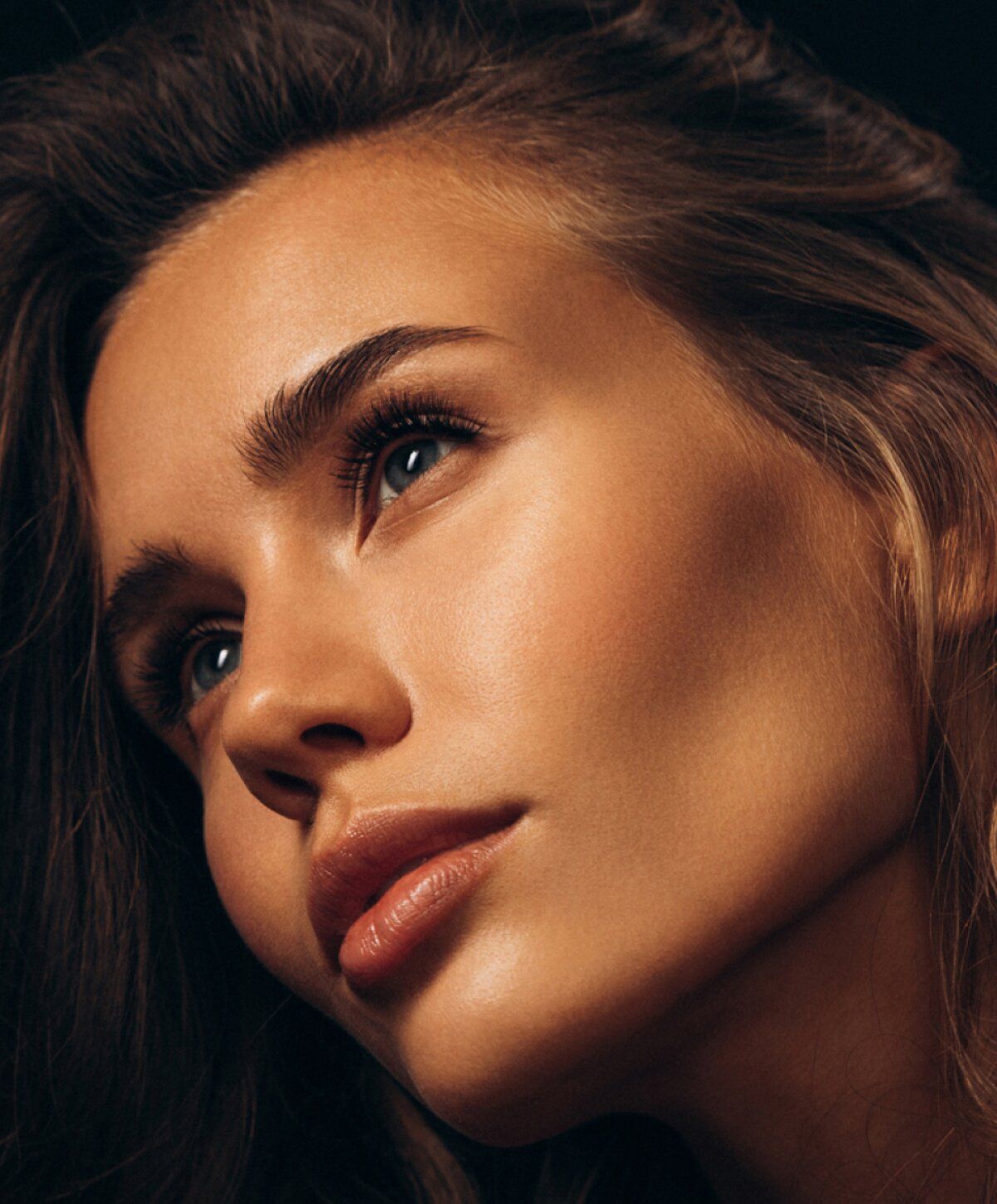 Close-up of a woman's face with soft lighting.