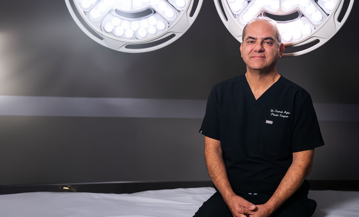 Surgeon sitting in a medical setting.