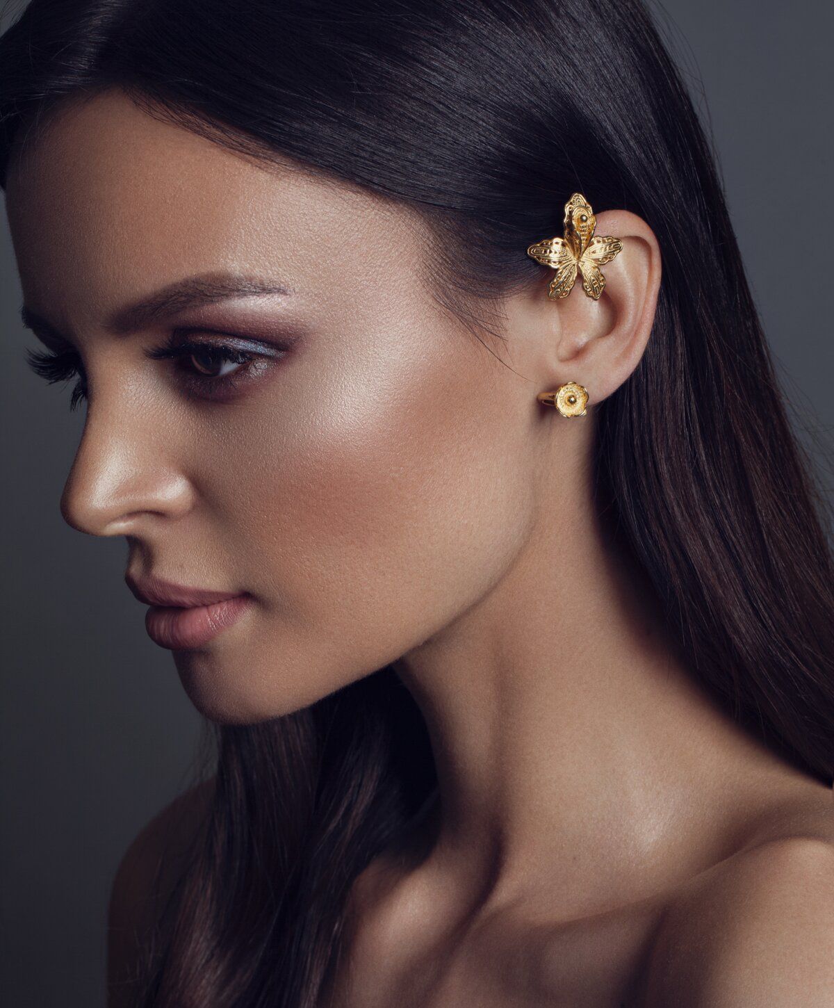 Close-up of model with gold butterfly earrings.