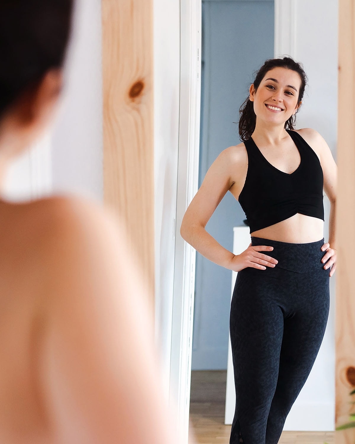 Woman smiling at her reflection in mirror.