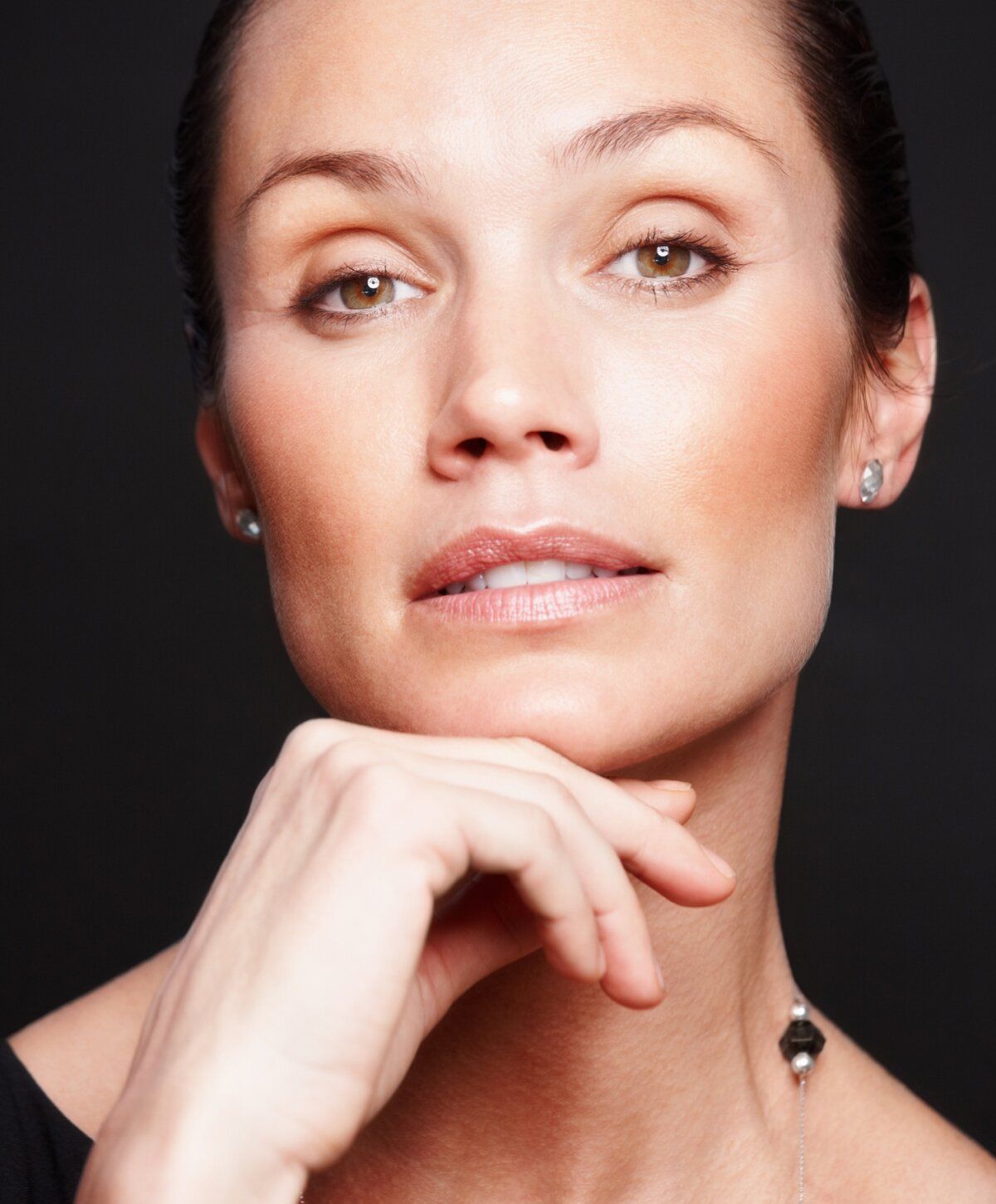 Thoughtful woman with elegant hairstyle and jewelry.