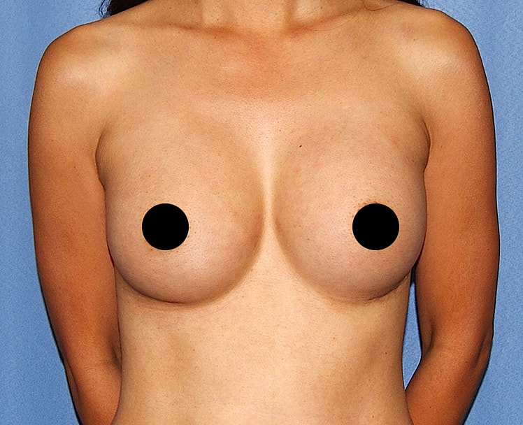 Nude woman standing against a blue background