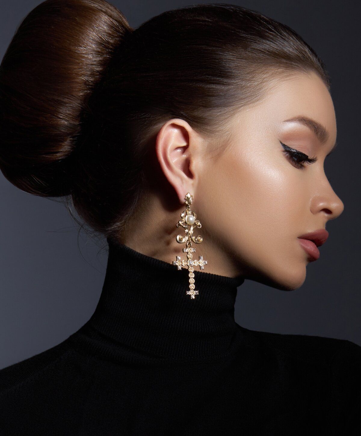 Elegant woman with ornate cross earrings.