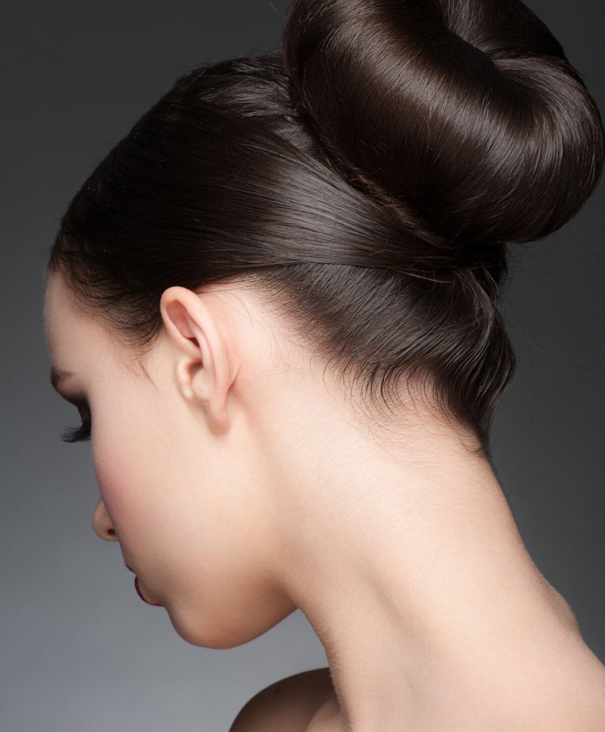 Profile view of a woman with elegant bun hairstyle.