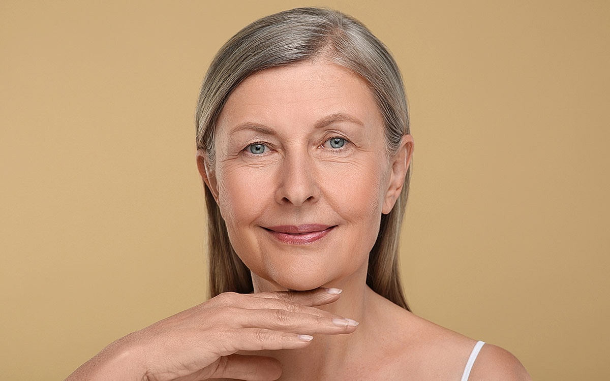 Smiling older woman with neutral background