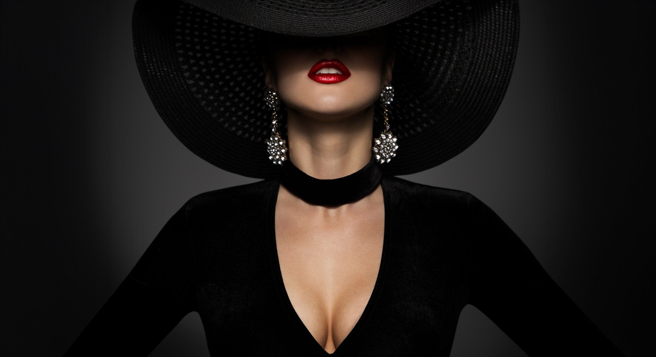 Elegant figure in black with oversized hat.