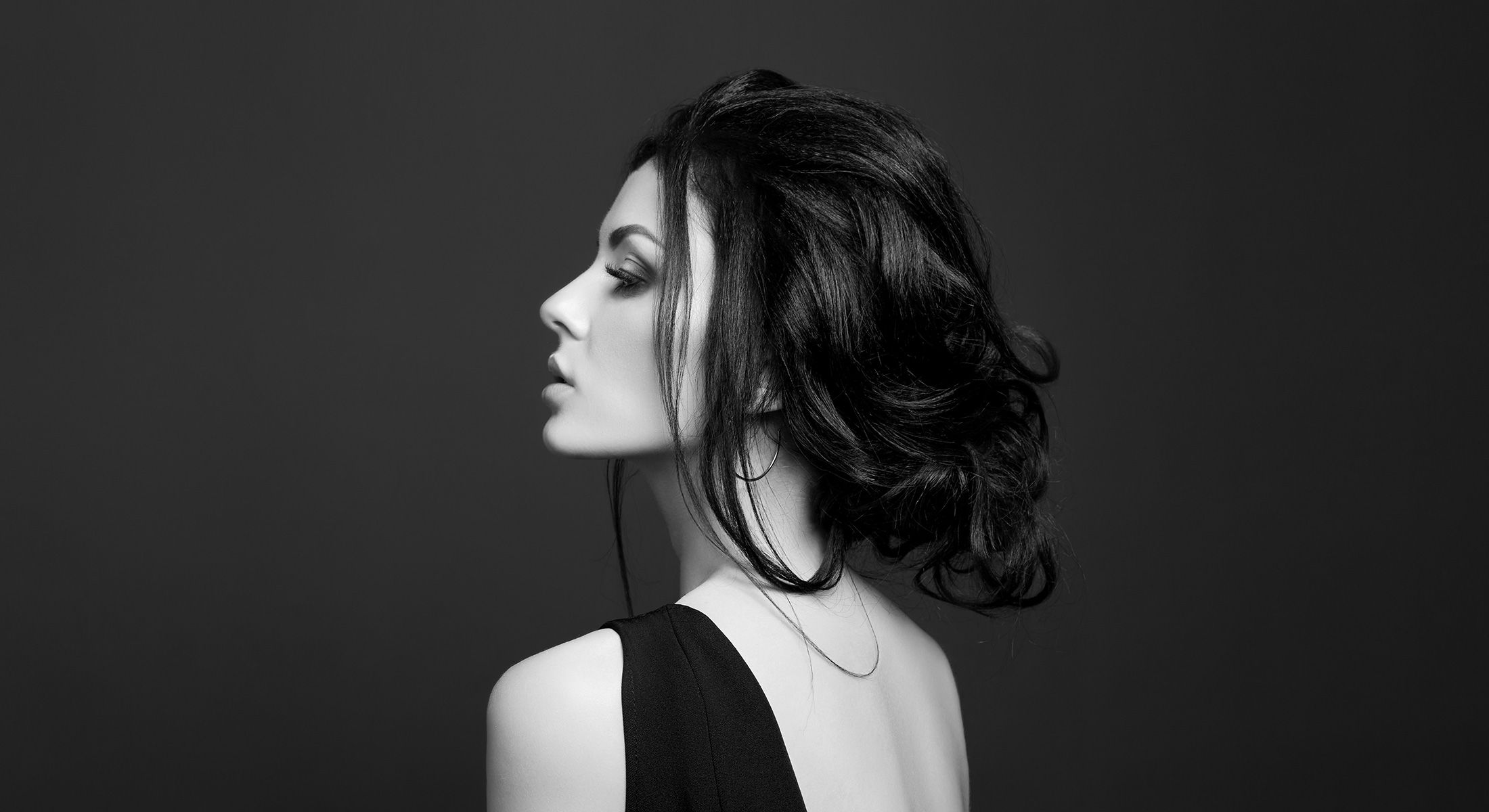 Profile of elegant attractive dark haired woman wearing a black dress