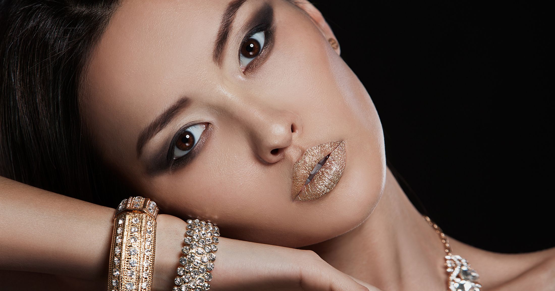 Beautiful eastern asian female model with gold and diamond jewelry and matching lipstick