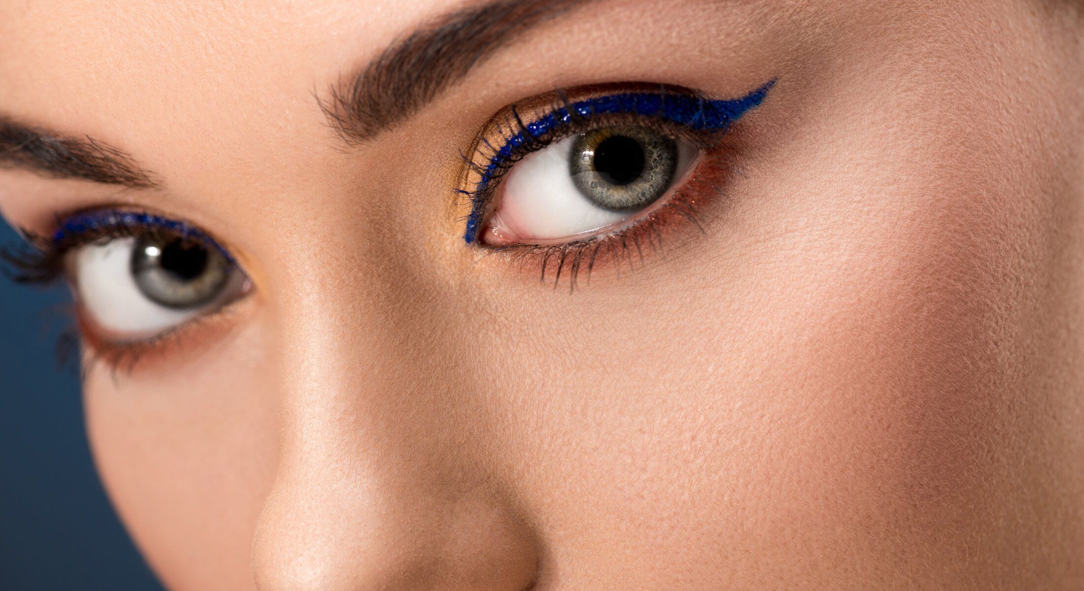 Close-up of eye with bold blue eyeliner.