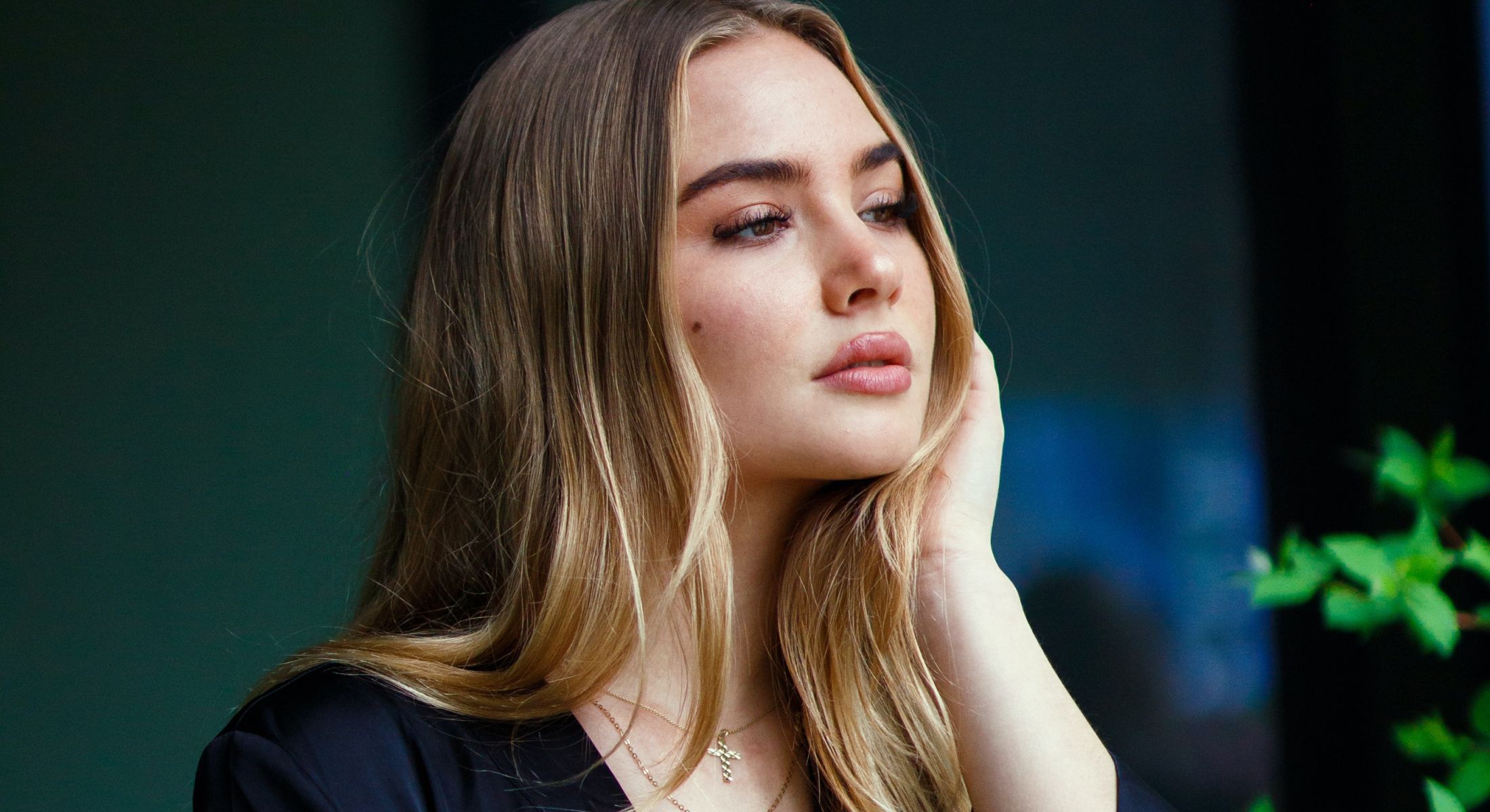 Thoughtful woman with long hair in natural light.