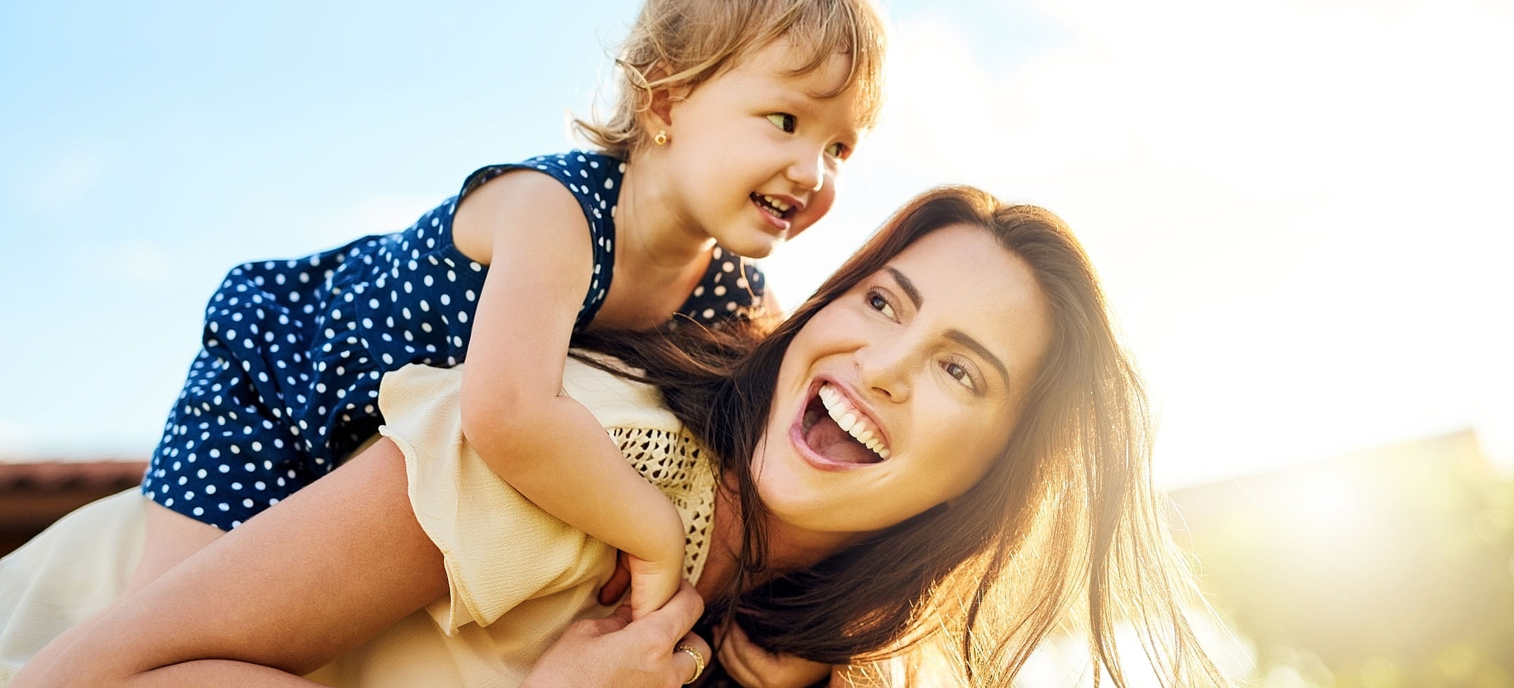Mother and daughter enjoying playful outdoor moment.