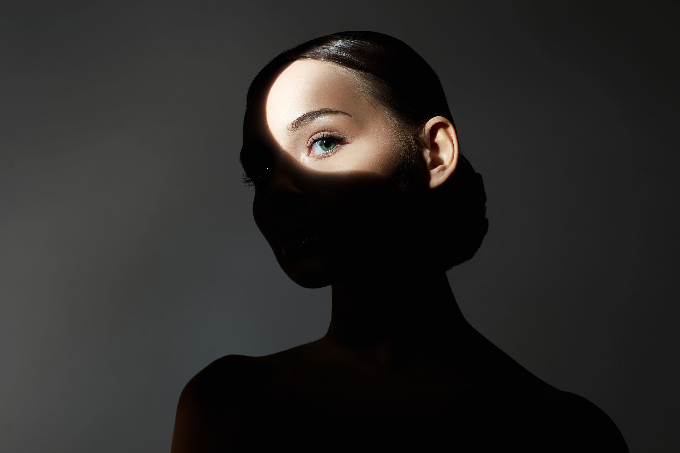Silhouette of a woman's face illuminated partially.