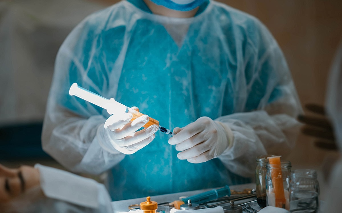 Medical professional preparing a syringe in lab.