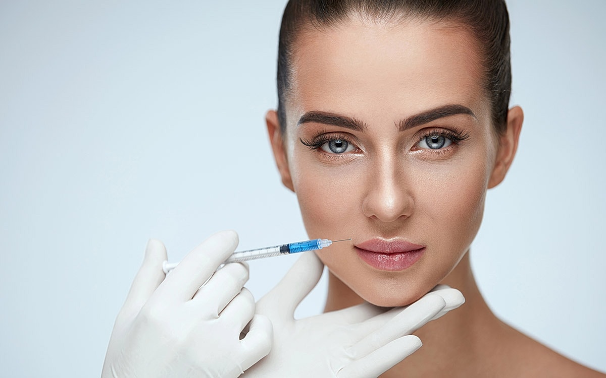 Woman receiving cosmetic treatment with a syringe.