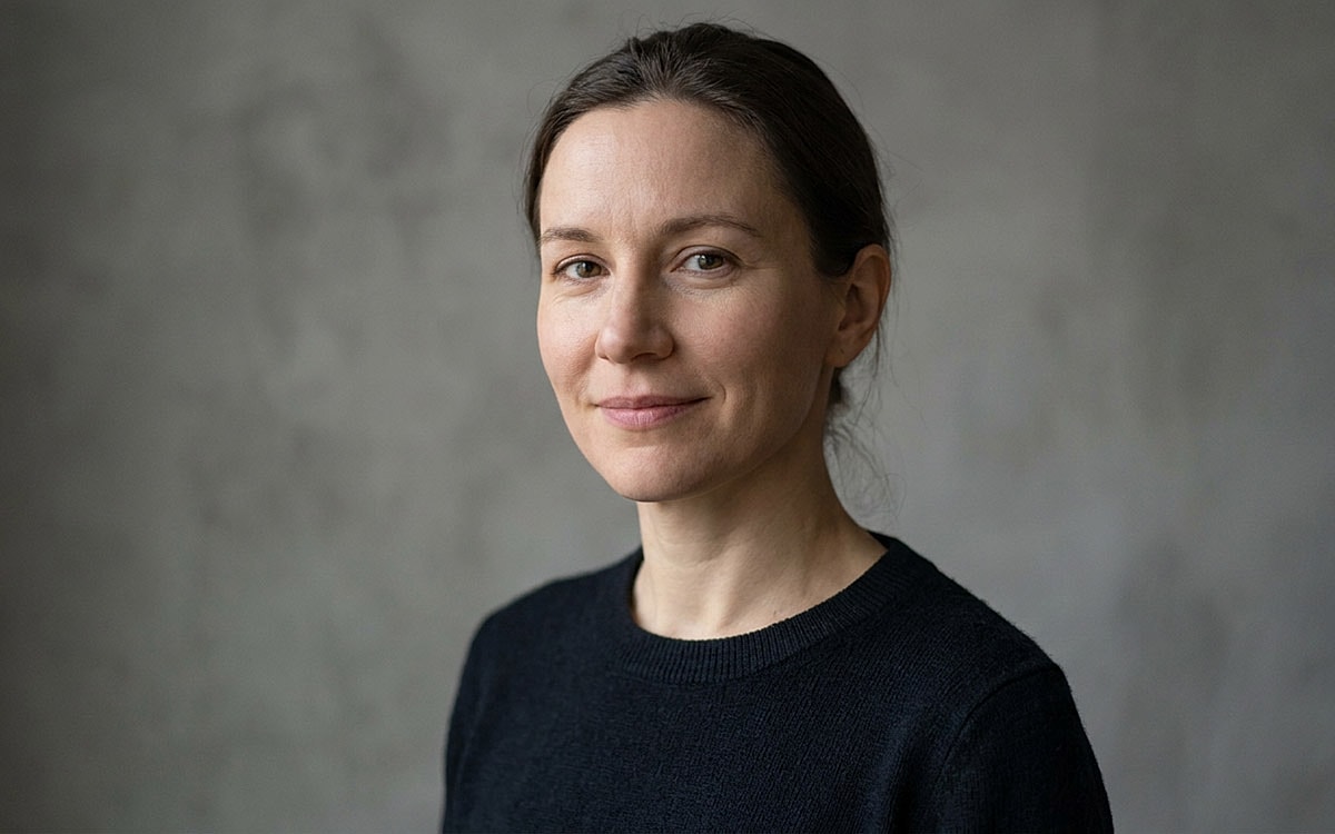 Woman with dark hair in a black sweater.