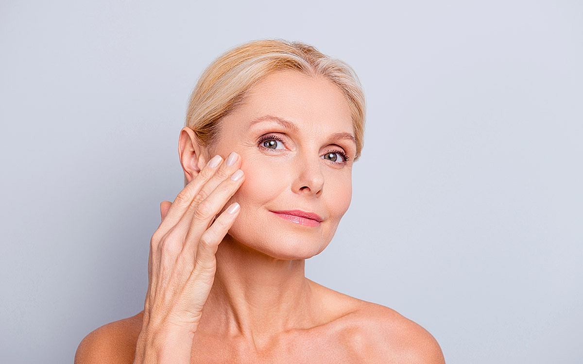 Woman applying skincare on her face.