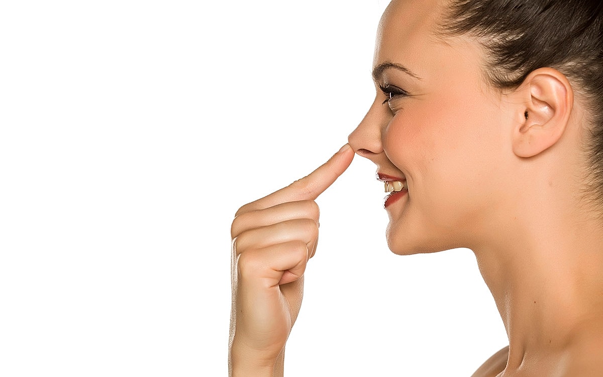 Woman playfully touching her nose with finger.