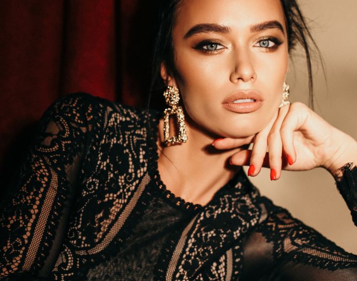 Elegant woman with striking eyes and earrings.