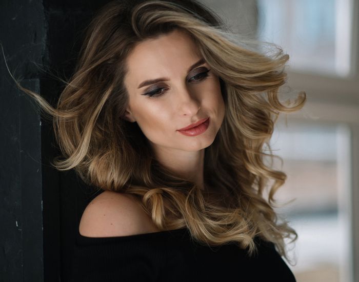 Woman with flowing hair in soft lighting.