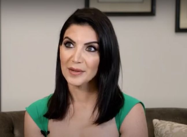 Woman with long dark hair in green top.